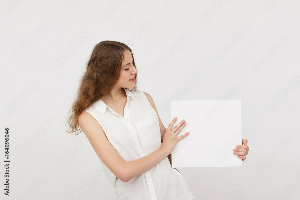 Young woman holding blank poster.Smiling woman sign board holding. Girl showing banner with copy space. Young woman holding blank poster.Smiling woman sign board holding. Girl showing banner with copy space.