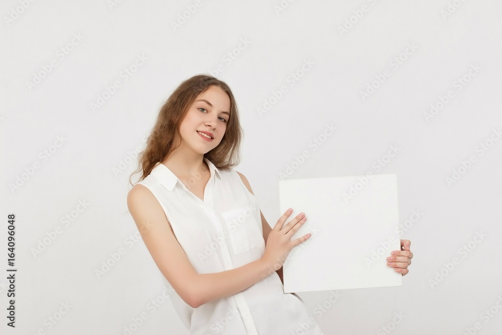 Young woman holding blank poster.Smiling woman sign board holding. Girl showing banner with copy space. Young woman holding blank poster.Smiling woman sign board holding. Girl showing banner with copy space.