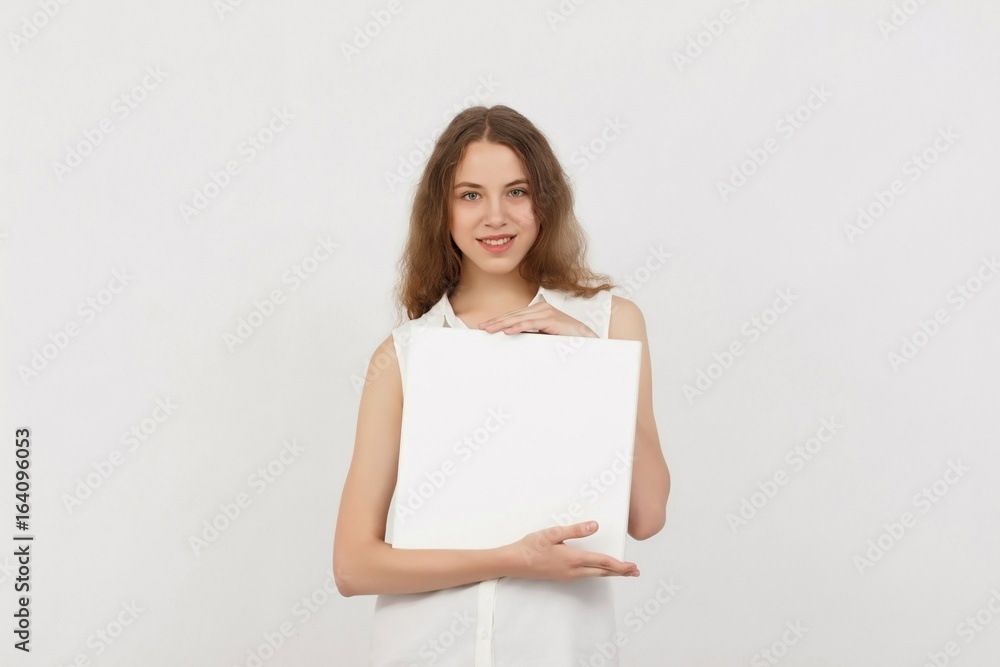 Young woman holding blank poster.Smiling woman sign board holding. Girl showing banner with copy space. Young woman holding blank poster.Smiling woman sign board holding. Girl showing banner with copy space.