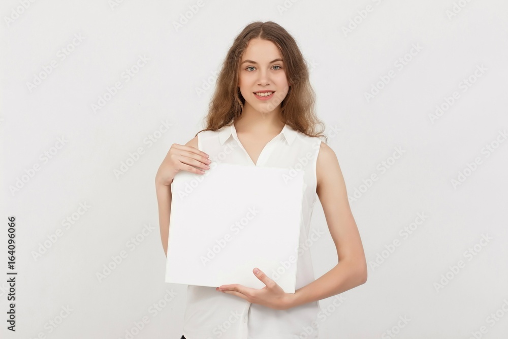 Young woman holding blank poster.Smiling woman sign board holding. Girl showing banner with copy space. Young woman holding blank poster.Smiling woman sign board holding. Girl showing banner with copy space.