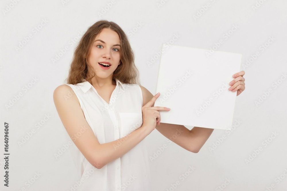 Young woman holding blank poster.Smiling woman sign board holding. Girl showing banner with copy space. Young woman holding blank poster.Smiling woman sign board holding. Girl showing banner with copy space.