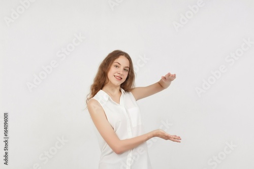 Portrait of young woman pointing hands finger at corner with copyspace isolated on a white background.Цoman with finger point up