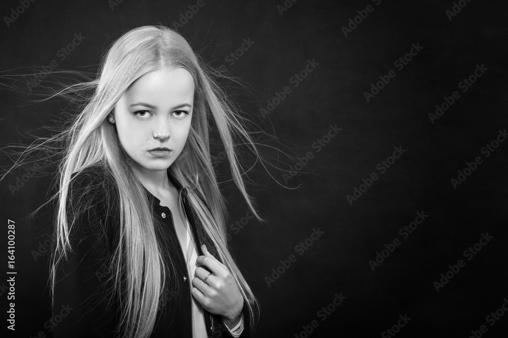 sad pensive blond girl on black background with copy space