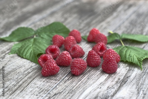 Ripe raspberries on a wooden background.