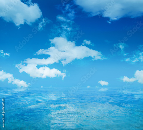 Infinite water surface over blue sky background