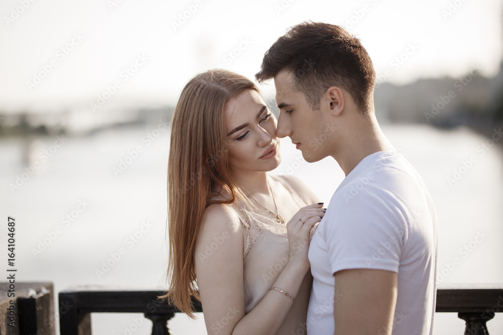 Portrait of young couple in love, enjoying the sunset in city