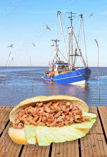 Krabbenbrötchen auf Bootssteg mit Fischkutter im Hintergrund, norddeutsche Spezialität