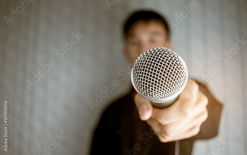 blurred of businessman speech talking and reporter with microphone at presentation in conference hall blue background