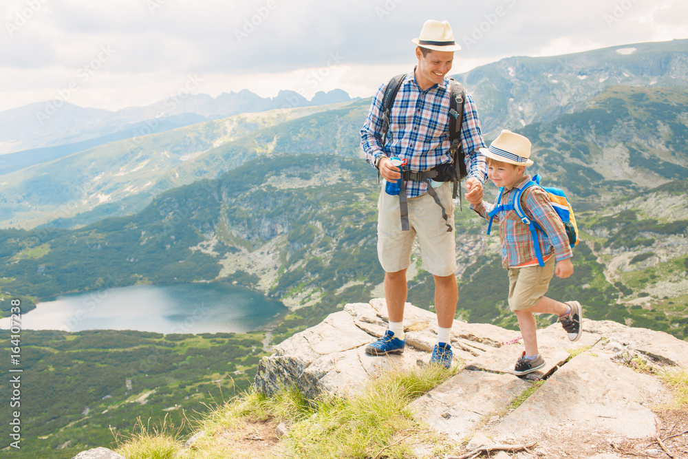 Father and son traveling in Rila mountains Bulgaria