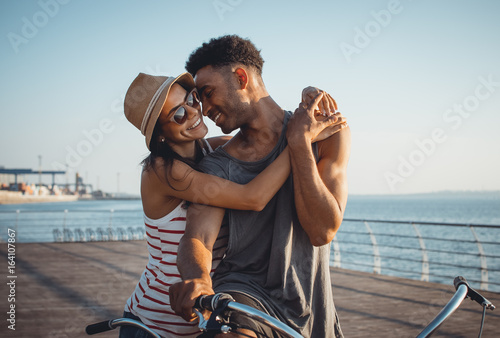 фотографія Portrait of a mixed race couple on tandem bicycle outdoors near the sea
