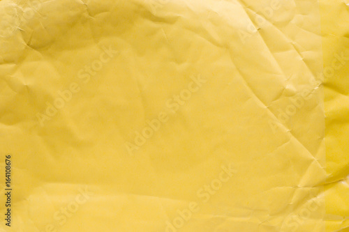 Yellow crumpled paper close up.