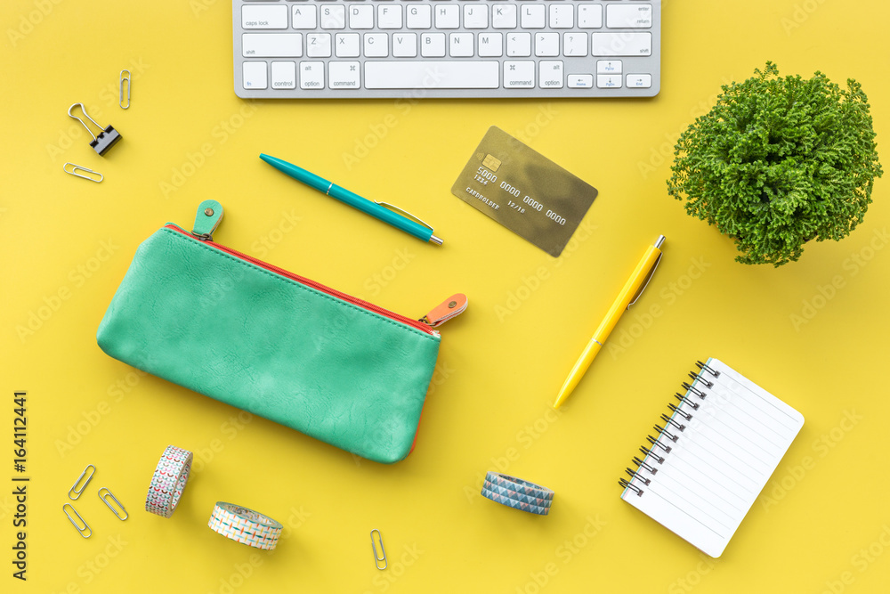Concept of paying by credit card online. Bank card in purse nearby keyboard on yellow background top view Concept of paying by credit card online. Bank card in purse nearby keyboard on yellow background top view