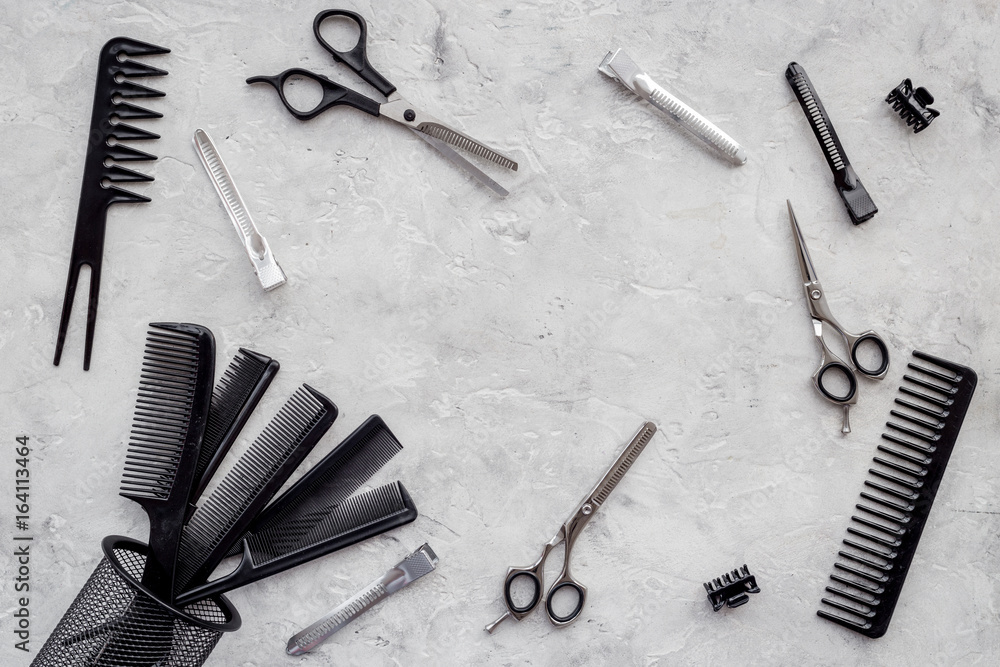 Combs and hairdresser tools on grey table background top view copyspace