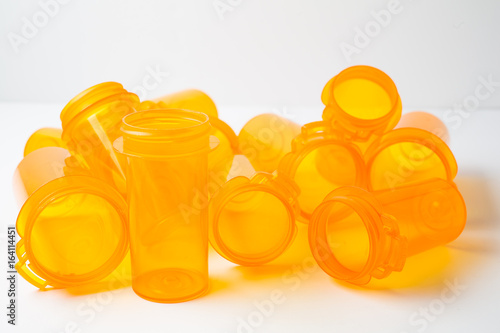 A dozen Prescription (Rx) vials piled on a white counter, conceptualizing either healthcare or addiction/substance abuse