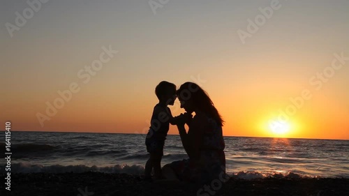 silhouette of mom and son at Sunset Beach sea ocean