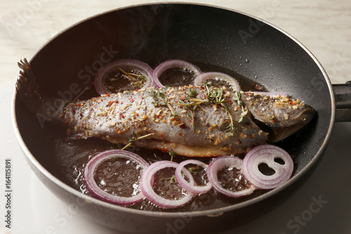 Cooking trout fish on frying pan, closeup
