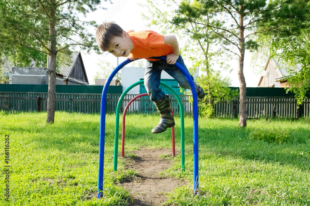 Fototapeta premium boy playing outdoors. Kid on playground, children activity. Child having fun. Active healthy childhood concept