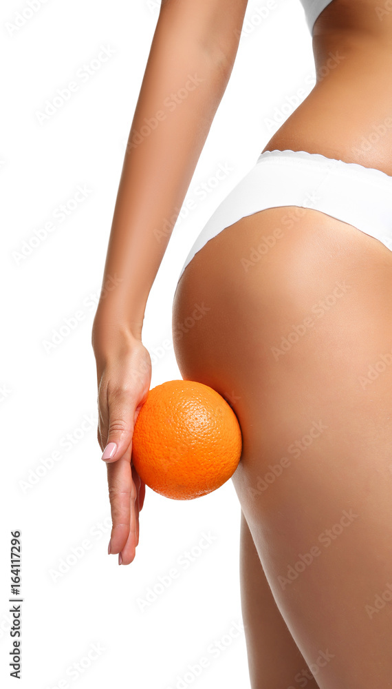 Young woman holding orange on white background. Cellulite problem concept - obrazy, fototapety, plakaty 