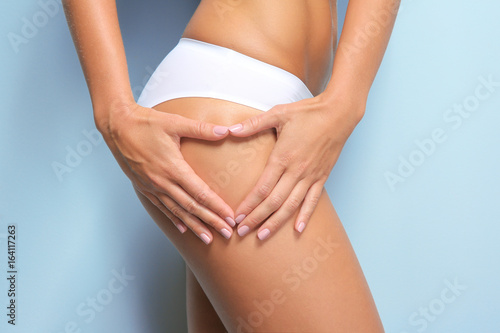 Young woman on light background. Cellulite problem concept