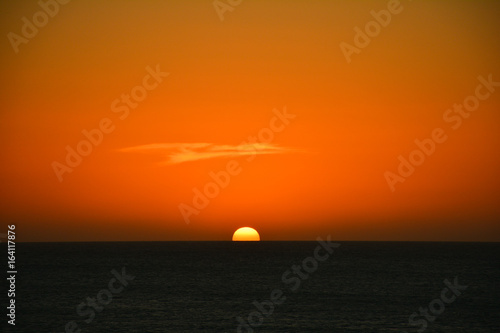 Fototapeta Naklejka Na Ścianę i Meble -  Orange sunset behind sea
