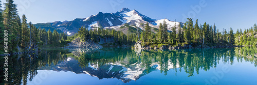 Fototapeta Wulkaniczne góry w świetle poranka odzwierciedlenie w spokojnych wodach jeziora.