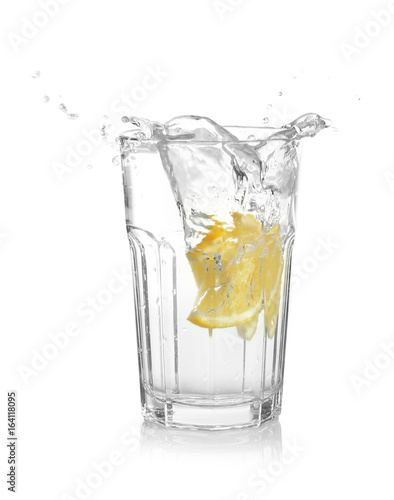 Glass of lemonade with splashing water on white background