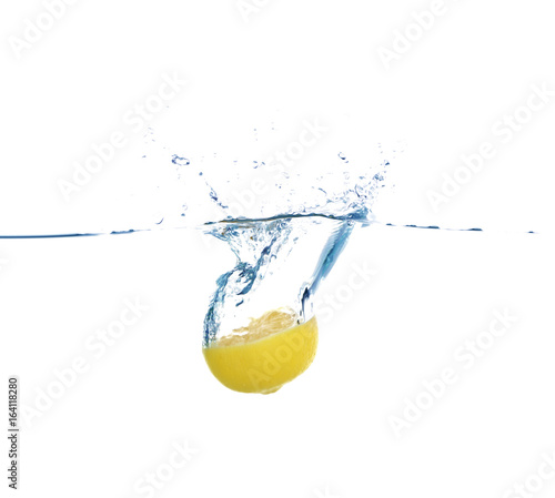 Falling lemon half into water on white background