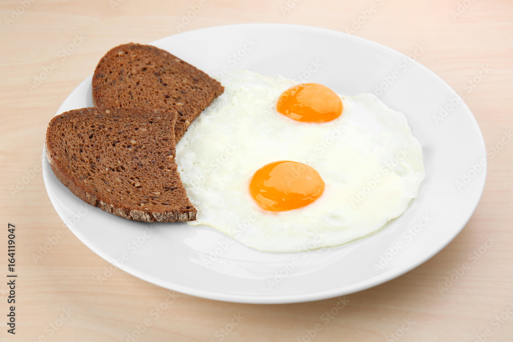 Homemade over easy fried eggs with bread on plate Homemade over easy fried eggs with bread on plate