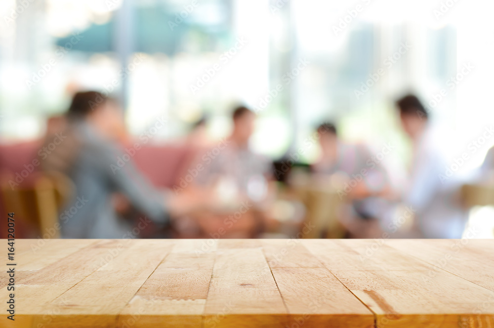 Wood table top with blurred people in cafe as background