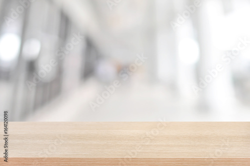 Wood table top on blurred white gray background of building hallway
