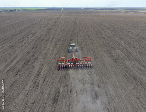 Sowing of corn. Tractor with a seeder on the field. Using a seeder for planting corn. photo