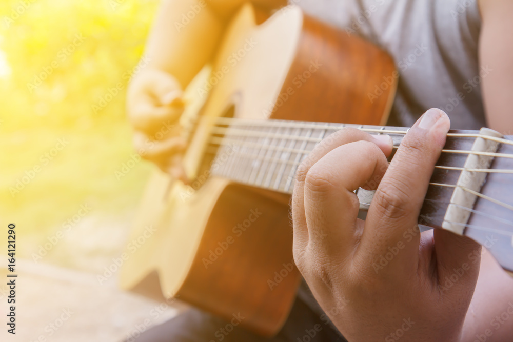 Fototapeta premium Man hands playing acoustic guitar, close up