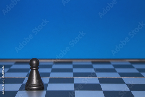 Chess as a policy. Black figure on a blue background.
