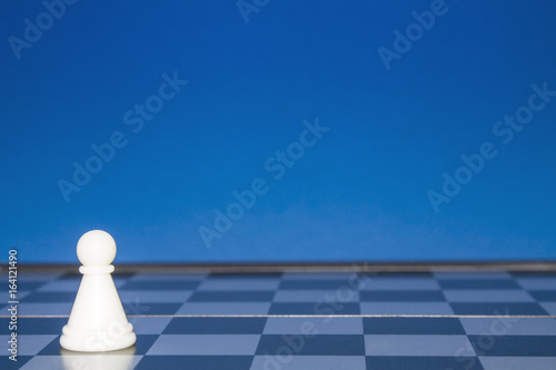 Chess as a policy. White figure on a blue background.
