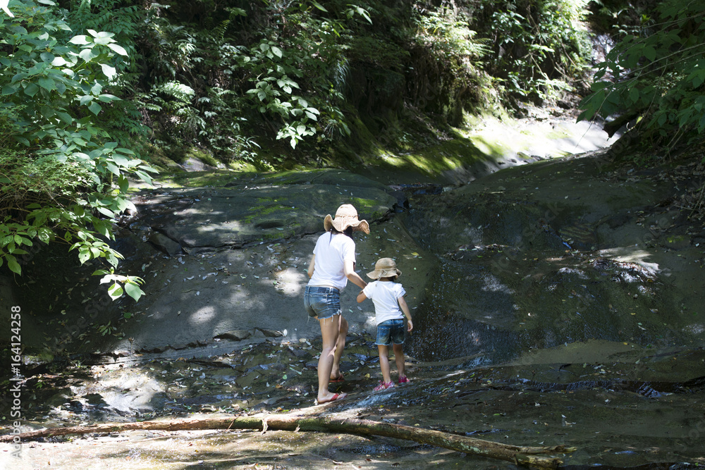 Mother and daughter playing in mountain stream