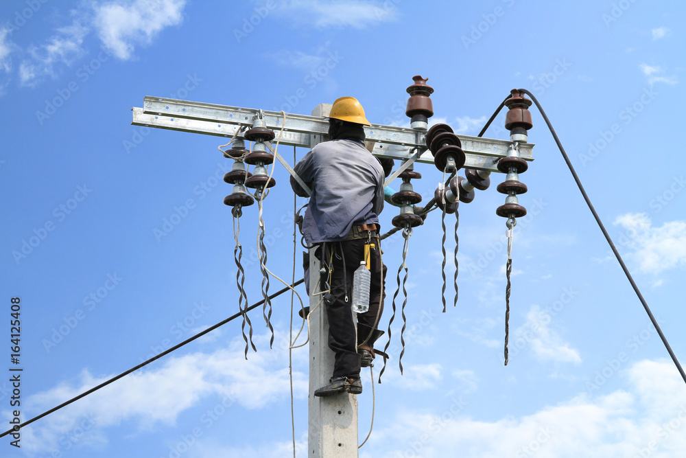 Obraz premium Electrician working on electric power pole