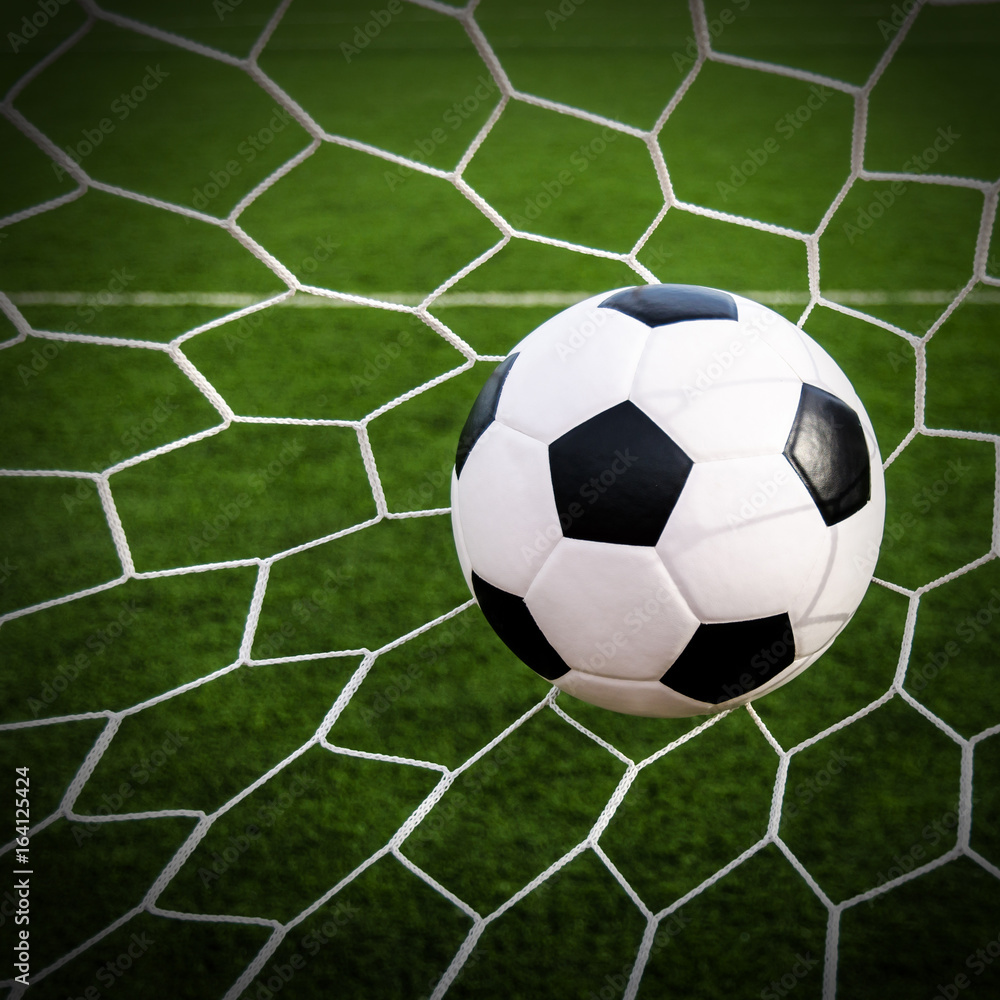 Soccer football in Goal net with green grass field. Soccer football in Goal net with green grass field.