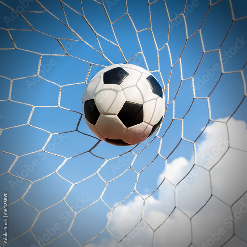 Fototapeta Naklejka Na Ścianę i Meble -  Soccer football in Goal net with the sky field.
