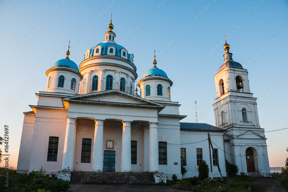 White Church with blue domes illuminated by the morning sun