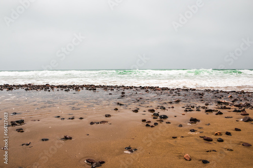 Coast, waves and beach with yellow sand and pebbles © keleny