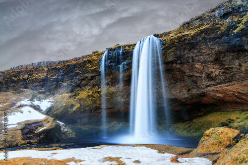 Beautiful view of the Seljalandsfoss waterfall in Iceland with ominous clouds in winter