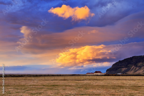 Beautiful vibrant sunset over a farm in the wide landscape of Iceland 