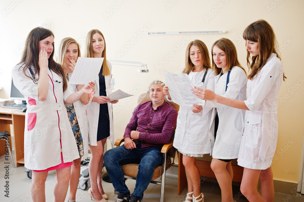 Naklejka premium Group of professional young doctors examining their patient's head.
