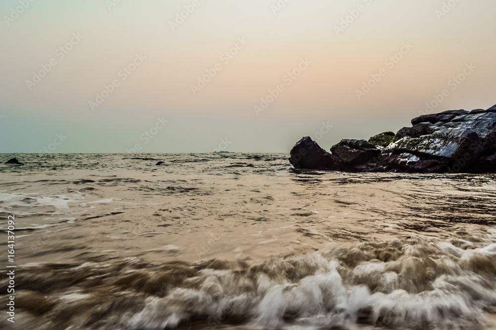 Fototapeta premium Sunset on a Beautiful Beach with Rocks, Goa, India