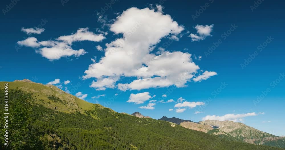 Mountain ridges and peaks with moving clouds and blue sky. Time lapse on daytime. The Alps in summer, Torino Province, Italy. Static version. Mountain ridges and peaks with moving clouds and blue sky. Time lapse on daytime. The Alps in summer, Torino Province, Italy. Static version.