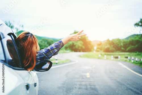Relaxed happy woman traveler on summer roadtrip vacation on hatchback ca photo