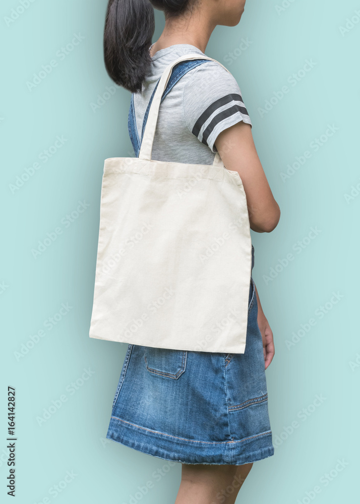 Canvas tote bag mockup cotton fabric texture on girl shoulder(clipping  path) in white cream color isolated on blue background Stock Photo | Adobe  Stock
