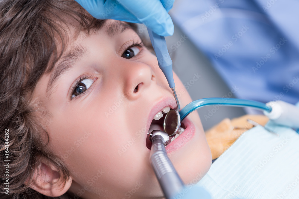 Fototapeta premium dentist examining teeth of little boy in dental hospital
