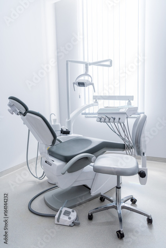 empty dentist office with chair and various dental equipment