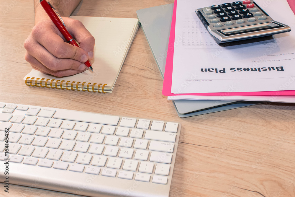 Businessman writing in a notebook. Man Working Determine Workspa Businessman writing in a notebook. Man Working Determine Workspa